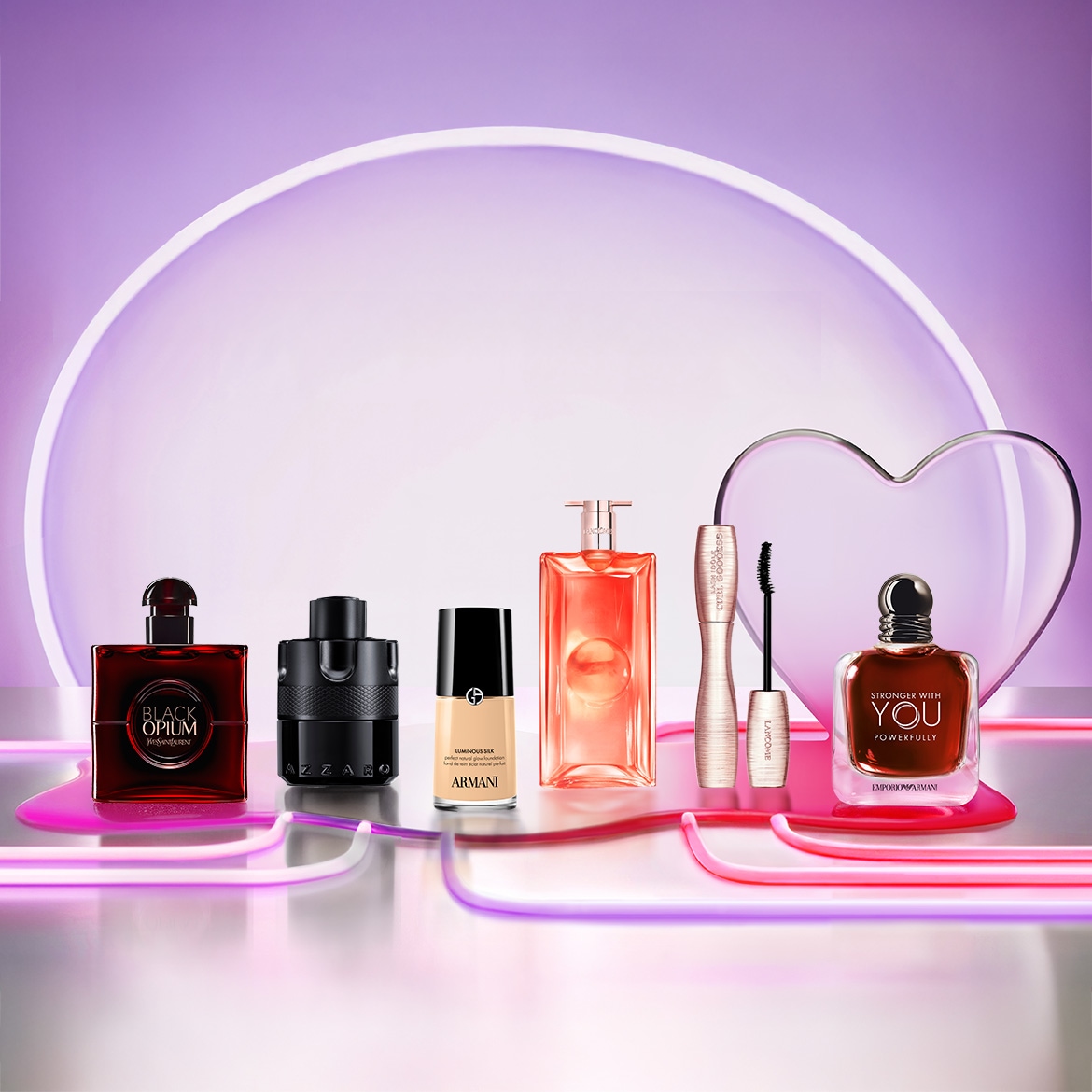 Entdecke eine Auswahl an Beauty-Produkten, darunter Parfums von Yves Saint Laurent und Armani, Make-up von Lancôme und eine Foundation von Armani, die auf einem glänzenden Tisch mit Neonlinien und einem Herz im Hintergrund präsentiert werden.