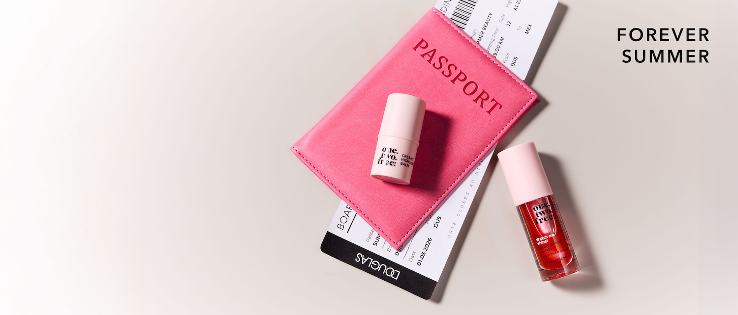 Mach dich bereit für den Sommer mit dem Creamy Highlight Balm und dem Shine Bright Lip Oil von One.Two.Free, die auf einem rosa Reisepass und einem Flugticket liegen.