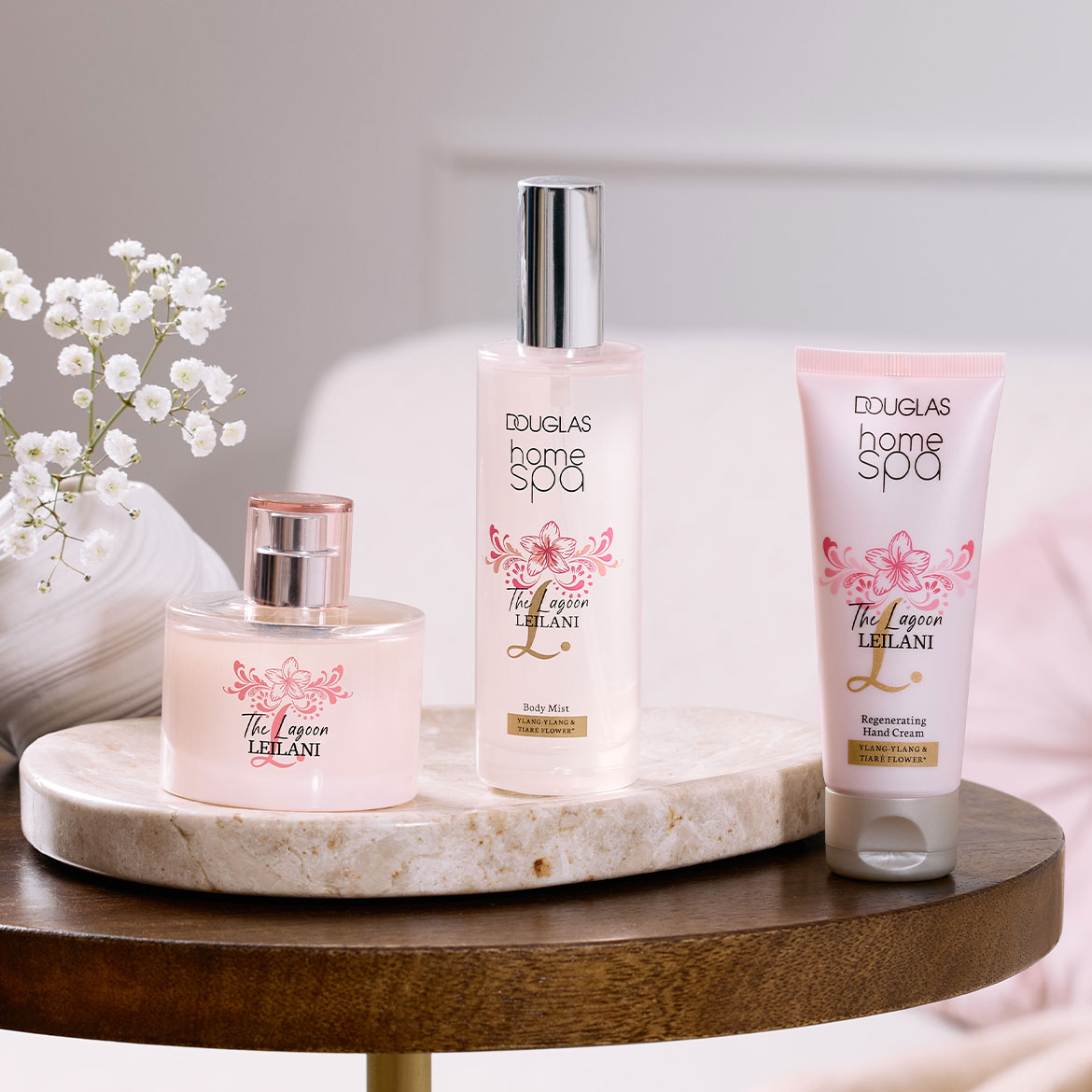 Douglas Home Spa präsentiert "The Lagoon Leilani" als Body Mist, Handcreme und Duft, verpackt in zarten Rosa- und Weißtönen mit floralen Akzenten.