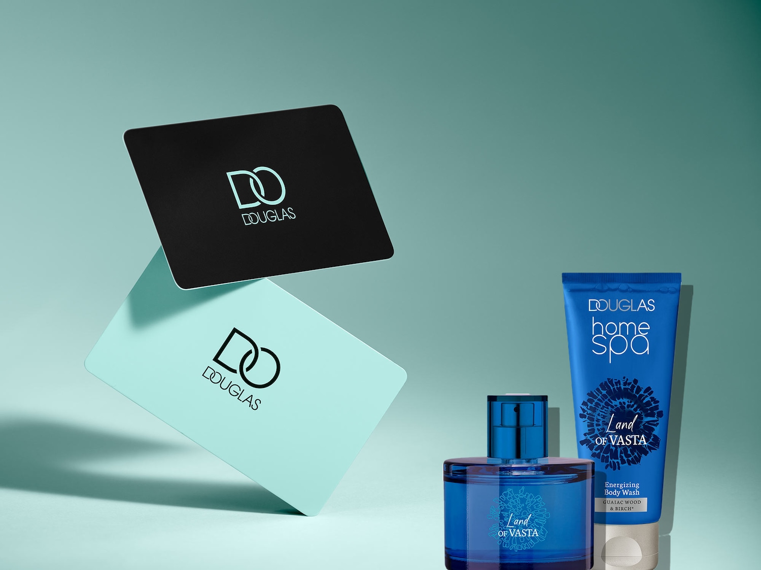 Entdecke das Douglas Home Spa Land of Vasta Set mit einem blauen Parfümflakon, einer passenden Body Wash Tube und eleganten Douglas Geschenkkarten in Schwarz und Türkis.