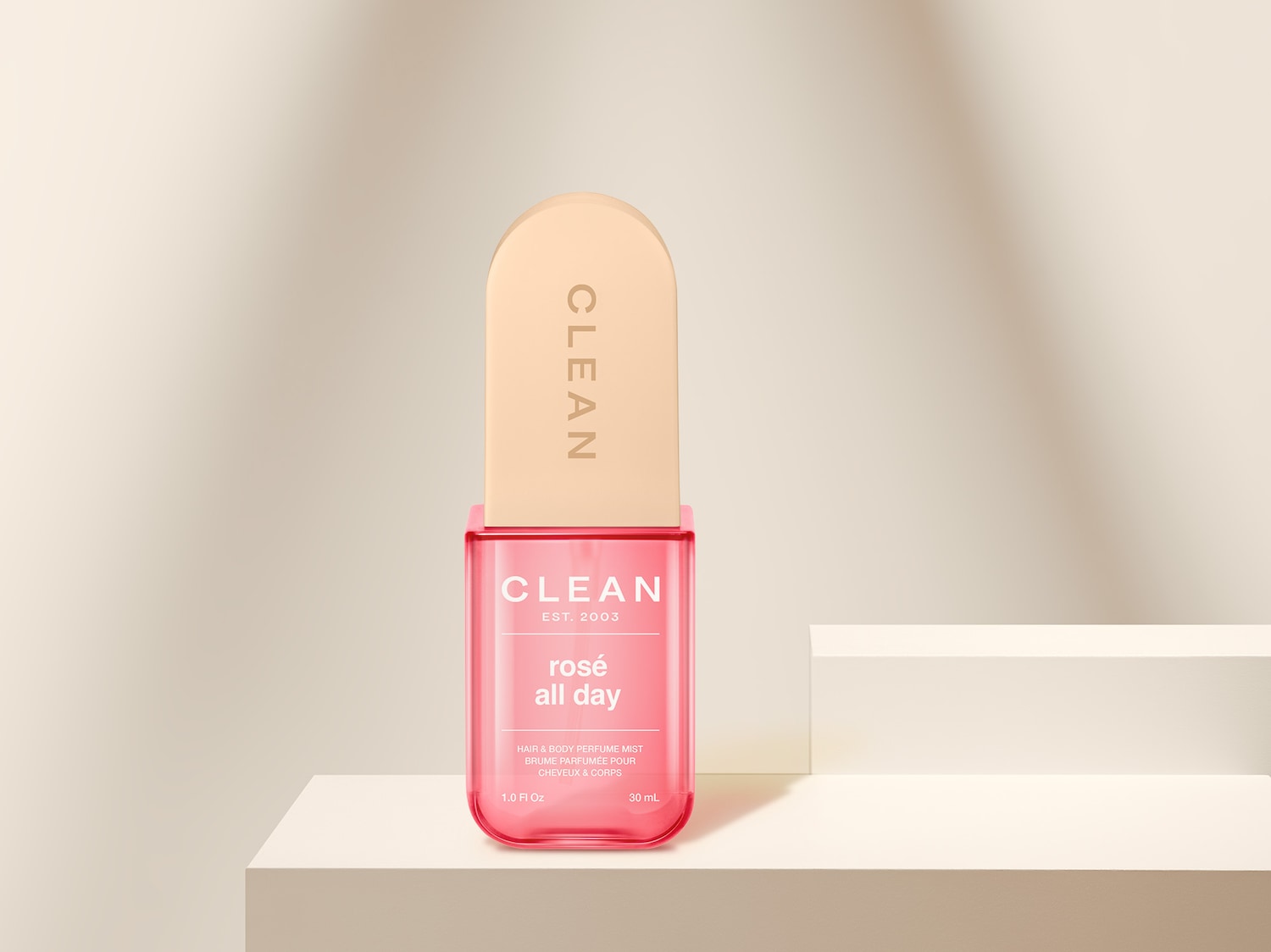 Das CLEAN Rosé All Day Hair & Body Perfume Mist in einer durchsichtigen, rosa getönten Flasche mit beigem Deckel, verspricht einen erfrischenden Duft für den ganzen Tag.