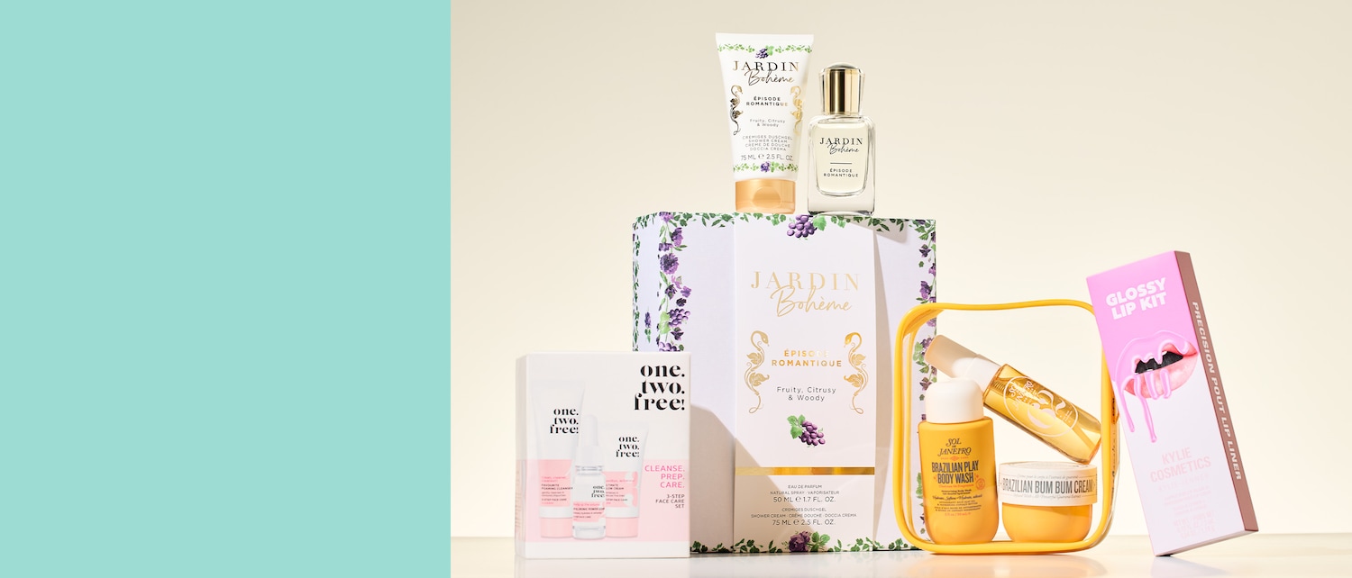 Verschiedene Schönheits- und Hautpflegeprodukte sind gestapelt, darunter Jardin Bohème Duschgel und Parfüm, ein One.Two.Free! 3-Stufen-Gesichtspflegeset, Sol de Janeiro Brazilian Play Body Wash und Bum Bum Cream sowie ein Kylie Cosmetics Glossy Lip Kit.