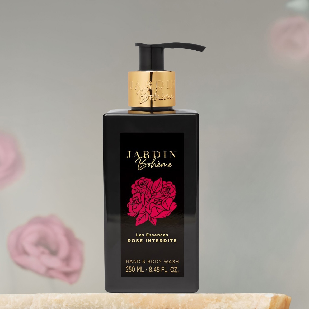 Schwarze, rechteckige Flasche Jardin Bohème Hand- und Körperwaschmittel mit goldenem Spender, verziert mit einem roten Rosenmotiv und dem Schriftzug "Les Essences ROSE INTERDITE".