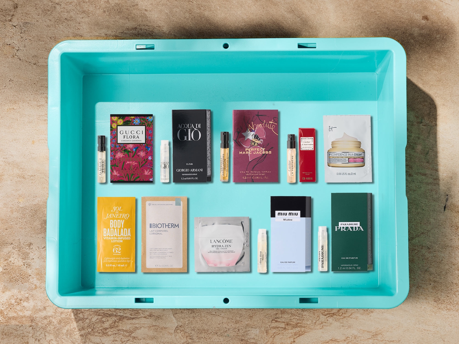 Beauty-Proben und Parfum-Samples verschiedener Marken ordentlich in einer türkisen Box arrangiert.
