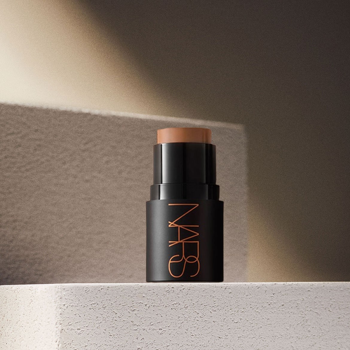 Der NARS Foundation Stick in einem eleganten schwarzen Gehäuse mit orangefarbenem Logo ist perfekt für einen makellosen Teint.