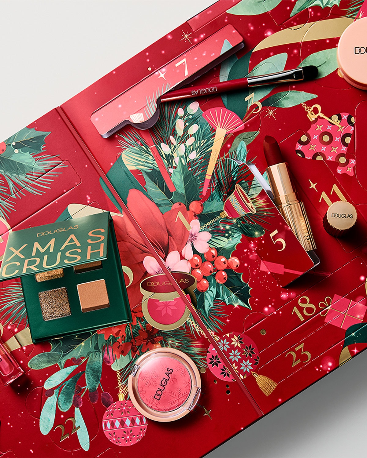 Der Douglas XMAS CRUSH Adventskalender ist ein festliches rotes Set mit grünen Blättern und roten Beeren, das eine Lidschattenpalette, Lippenstift, Rouge und Pinsel enthält.