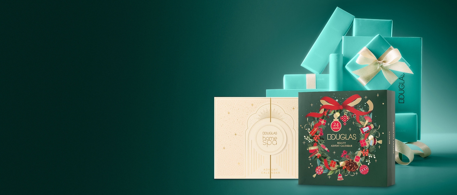 Ein Douglas Home Spa Adventskalender in Beige mit goldenen Sternen und ein Douglas Beauty Adventskalender in Dunkelgrün mit einem Weihnachtskranz und der Aufschrift „24 Überraschungen“ stehen vor einem Stapel türkisfarbener Douglas-Geschenkboxen.
