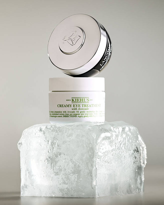 Kiehl's Creamy Eye Treatment mit Avocado auf einem Eisblock, darüber Lancôme Génifique Yeux für eine sanfte Feuchtigkeitspflege und einen wachen Blick.